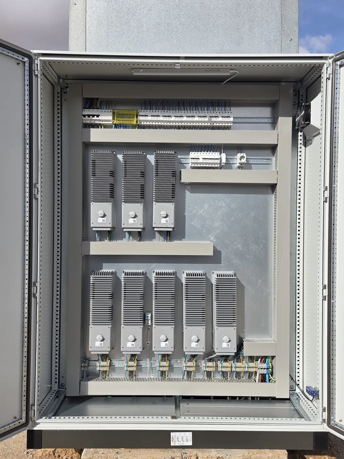 Armario eléctrico con los equipos de control de los proyectores ordenados por filas